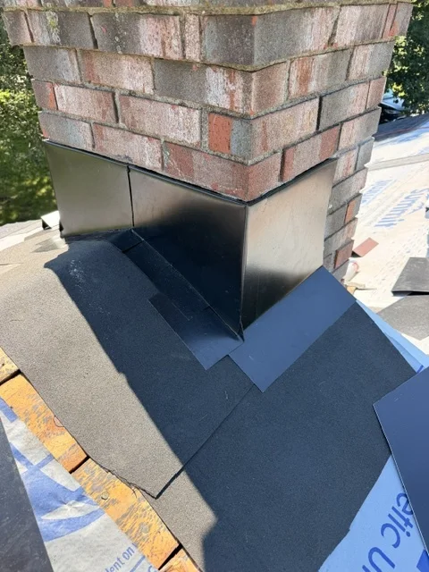 Brick chimney with new step and counter flashing over fresh underlayment